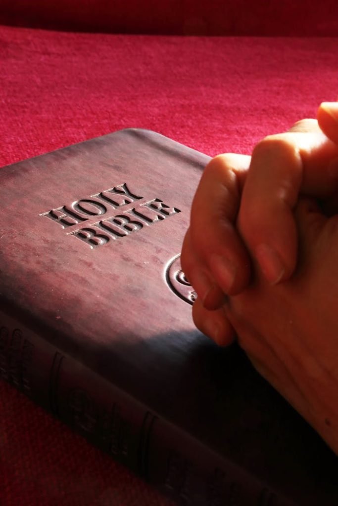 person-hands-on-holy-bible-267559 Close-up of hands praying on a Holy Bible, symbolizing faith and spirituality.