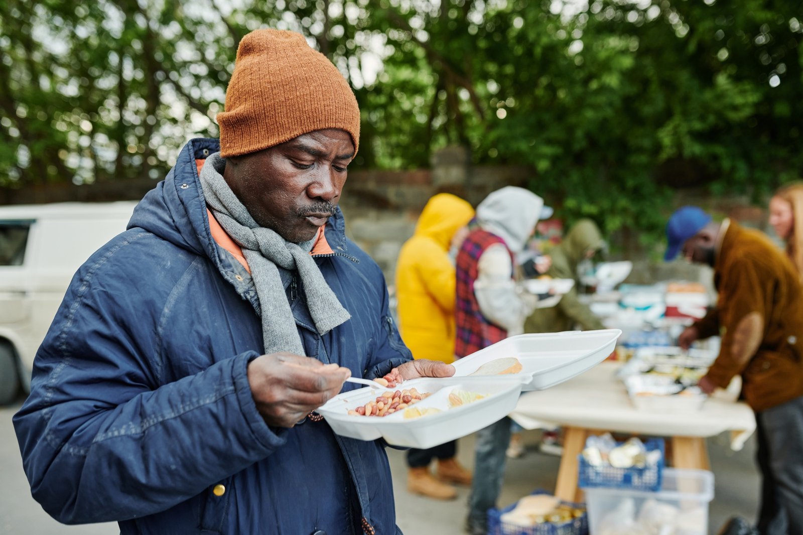 African homeless man eating charity food