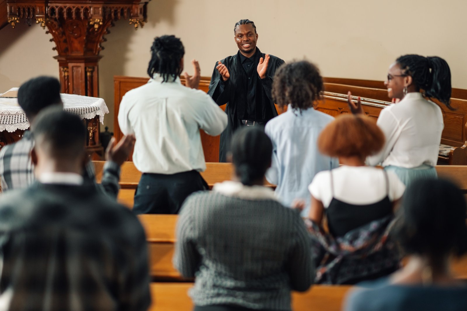 Congregation clapping while pastor is preaching in church